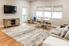 Relax in this spacious living area with a flat-screen TV, comfortable sofa, and dining table.