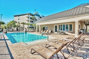 Relax by the pool surrounded by palm trees and lounge chairs.