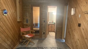 Un intérieur en bois avec une chaise pliante, un petit tapis et un sol carrelé.