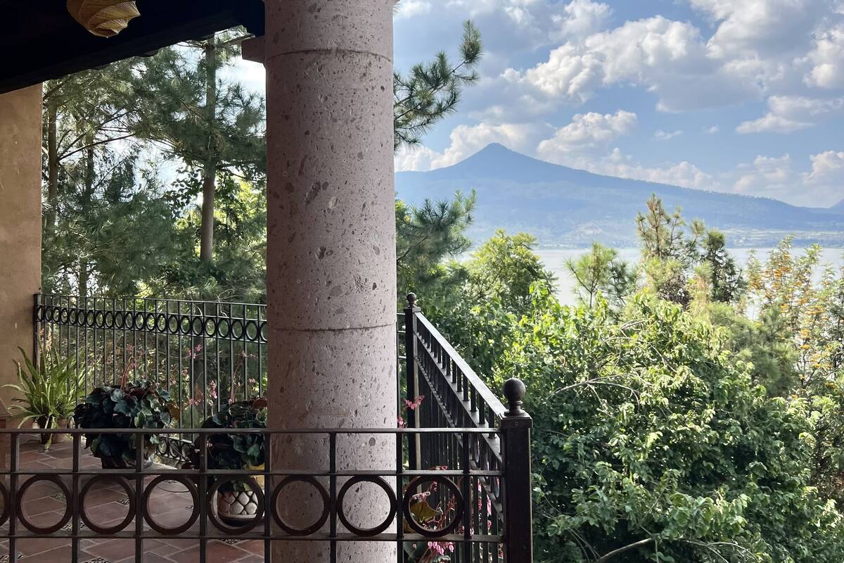 A balcony with a view of a mountain and trees.