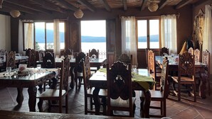 A restaurant with wooden furniture and a view of the mountains.