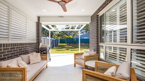 Relax in a comfortable seating area with a sofa and two chairs, surrounded by large windows offering views of the surrounding area.