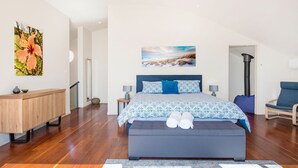 Un dormitorio moderno con una cama grande, un aparador de madera y vistas al exterior.