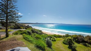 Vista costera con playa, vegetación y cielo despejado.
