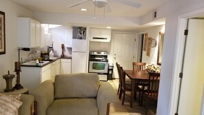 Un espace de vie compact comprenant un canapé, une table à manger et une kitchenette.
