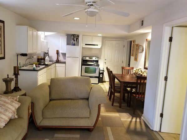 A compact living space with a sofa, dining table, and kitchenette.