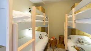 A dormitory room with bunk beds, a small wooden table, and a chair. - Bain à Remous+Terrasse Panoramique! Chalet Raffiné (Les Deux Alpes)