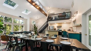 A spacious dining area with a high ceiling, skylights, and a view of the outdoors. - Modern Poconos Game House! Hot Tub, Fire Pit (East Stroudsburg)