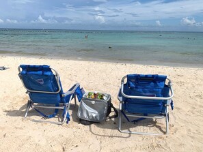 Una playa cerca, sillas reclinables de playa, toallas de playa