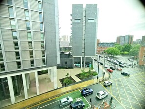 A multi-story building with a modern architectural design, featuring large windows and a flat roof. - 2-bed Apartment Near City Centre (Salford)