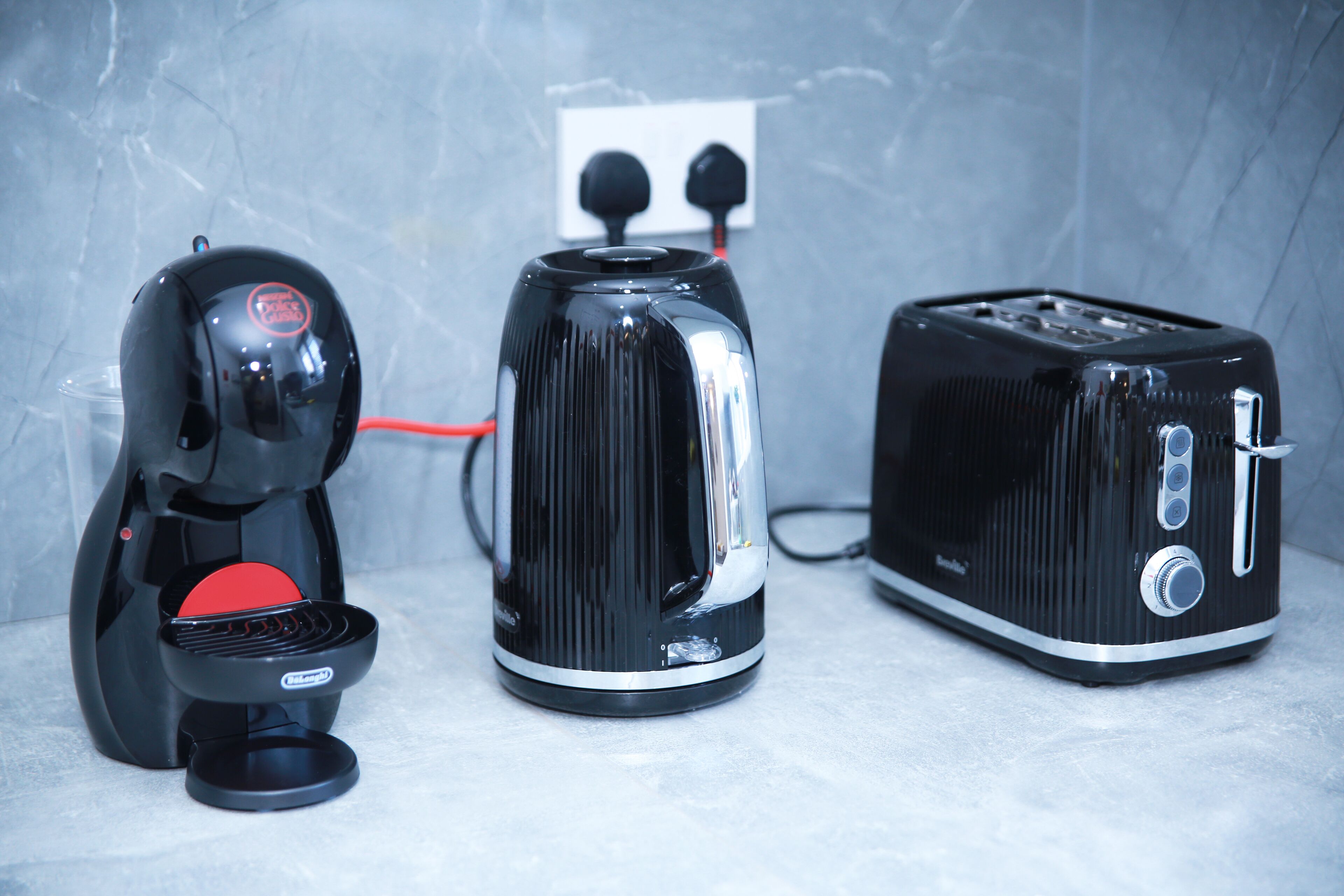 Una cocina con cafetera, hervidor y tostadora.