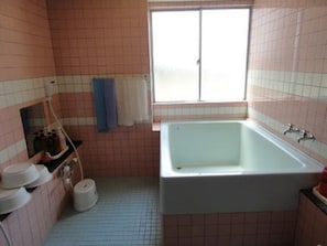 Un bagno con una vasca, una finestra e pareti piastrellate.