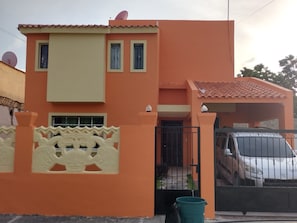 A two-story building with a flat roof and a gated entrance.