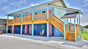A two-story building with a covered porch and a staircase. - Monterrey Motel Padre Island, Corpus Christi By Oyo (Corpus Christi)