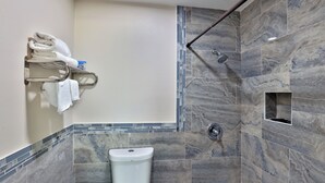 A modern bathroom with a shower, a toilet, and a towel rack. - Monterrey Motel Padre Island, Corpus Christi By Oyo (Corpus Christi)