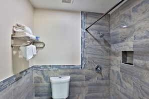 A modern bathroom with a shower, a toilet, and a towel rack. - Monterrey Motel Padre Island, Corpus Christi By Oyo (Corpus Christi)