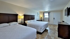 A hotel room with two beds, a desk, a chair, a TV, and a door. - Monterrey Motel Padre Island, Corpus Christi By Oyo (Corpus Christi)