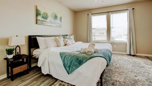 A bedroom with a bed, nightstand, lamp, and a painting on the wall. - 5 Mins to Ruoff+Dog Friendly+Fenced yard+Fast WiFi (Noblesville)