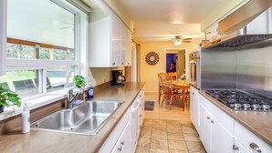 A modern kitchen with a large sink, stove, and dining area. - 10 Mi to Silverwood: Secluded Getaway! (Spirit Lake)