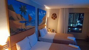 A hotel room with two beds, a painting of a beach scene, a window with a city view, and a clock on the wall. - Ilusion Flats Aconchego de Ponta Negra (Natal)