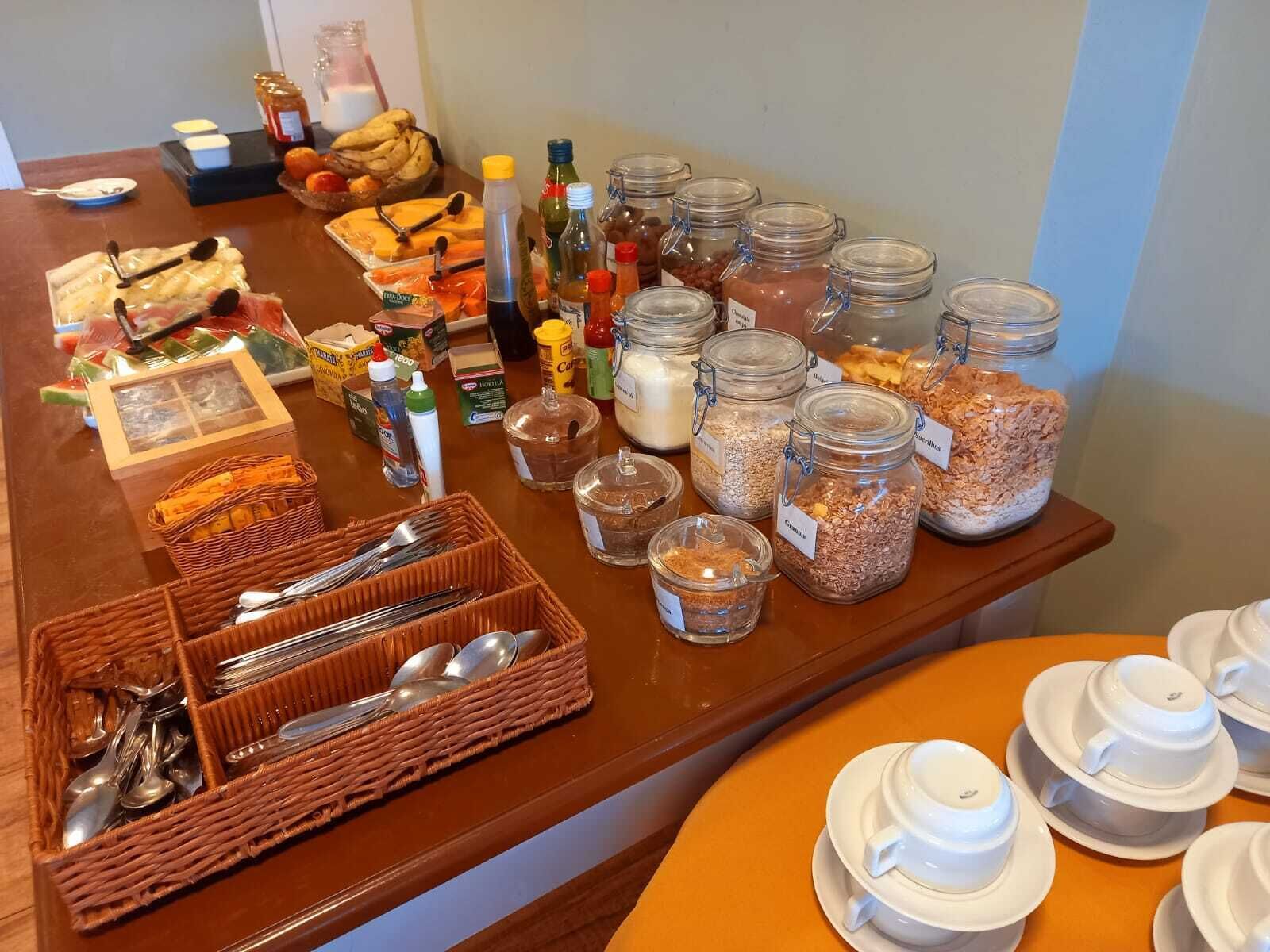 A breakfast buffet with various food items, condiments, and utensils.