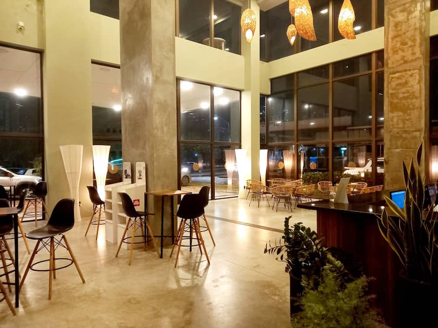 A spacious indoor area with high ceilings, large windows, and modern lighting fixtures.