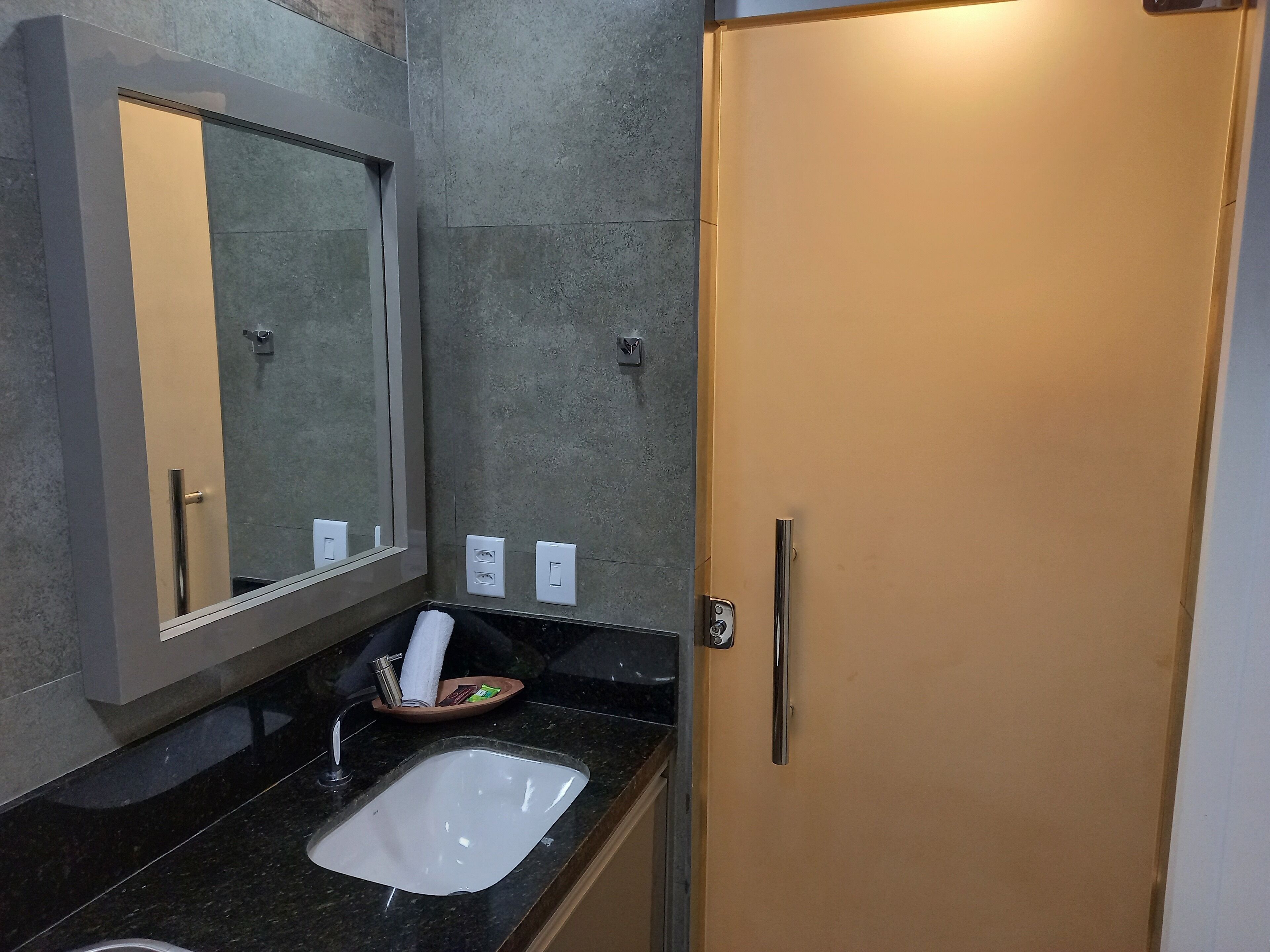 Ein modernes Badezimmer mit großem Spiegel, Waschbecken und Toilette.