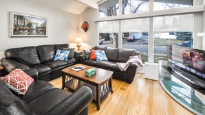 A modern living room with a leather sofa, a wooden coffee table, and a flat-screen TV.