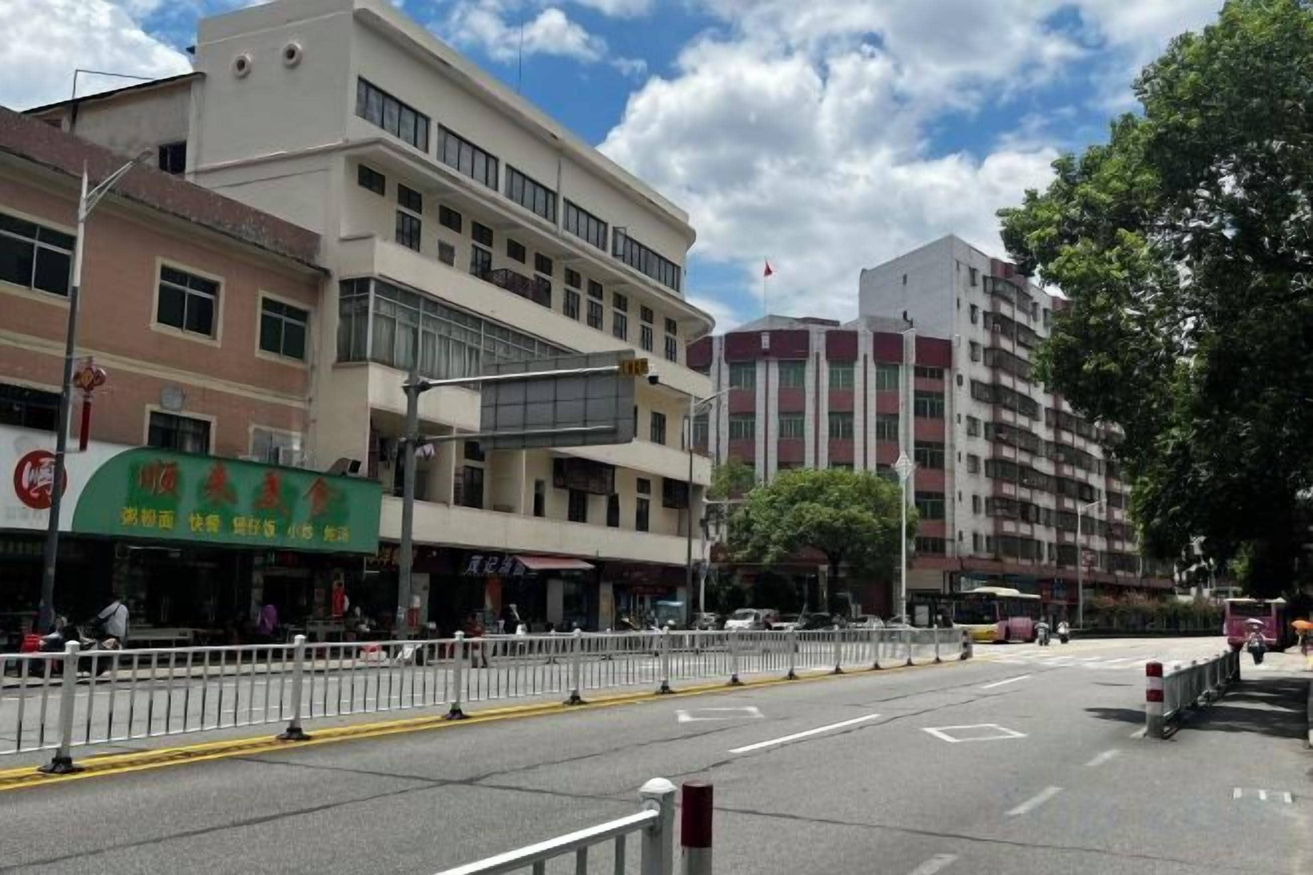 A street view with buildings, a clear sky, and a pedestrian crossing.
