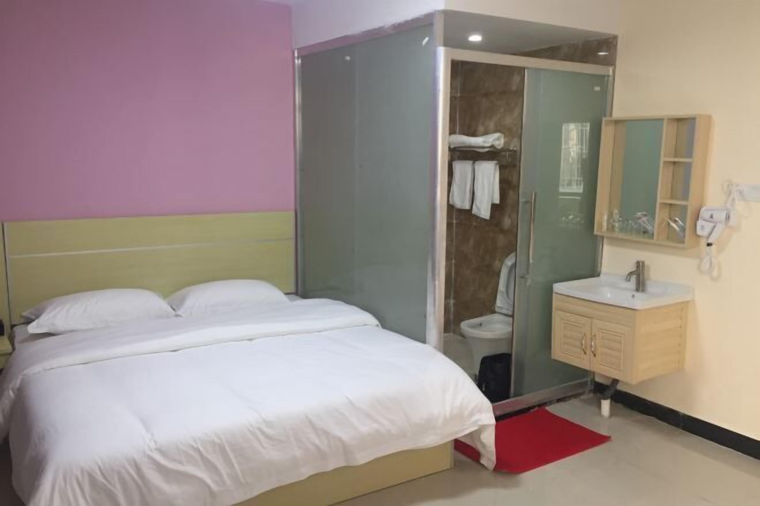 Un dormitorio con cama, cabina de ducha, lavabo y espejo.
