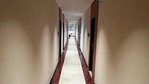 A long, narrow hallway with a marble floor and beige walls. - shangyoucsgy (Taishan)