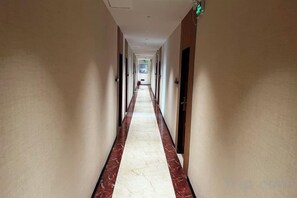 A long, narrow hotel corridor with doors on both sides and a marble floor. - shangyoucsgy (Taishan)