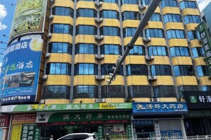 A multi-story building with several commercial establishments on the ground floor, including a pharmacy and a restaurant. - shangyoucsgy (Taishan)