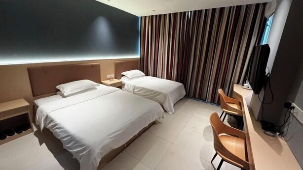 A hotel room with two beds, a desk, a chair, a TV, and a striped curtain. - shangyoucsgy (Taishan)