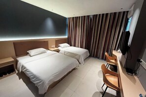 A hotel room with two beds, a desk, a chair, a TV, and a striped curtain. - shangyoucsgy (Taishan)