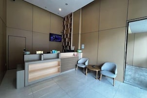 A reception area with a counter, seating, and a TV screen.