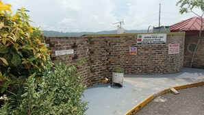 Un mur de briques orné de plusieurs panneaux, dont un pour un café Upper Deck proposant de la cuisine jamaïcaine et des cocktails, et un autre indiquant une durée de 10 minutes pour le chargement et le déchargement.