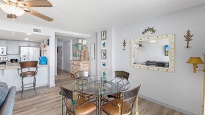 A modern kitchen with white cabinets, a blue countertop, and a ceiling fan. - Sandcastle Condominiums Unit 104 (Port Aransas)