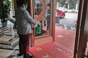 Una persona limpiando un vidrio con un pulverizador.