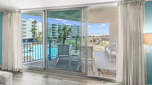 Un balcón con piscina, mobiliario exterior y vista a un edificio de hotel.