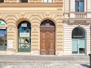 Three storefronts offer a variety of services: dining, gardening supplies, and hair care.