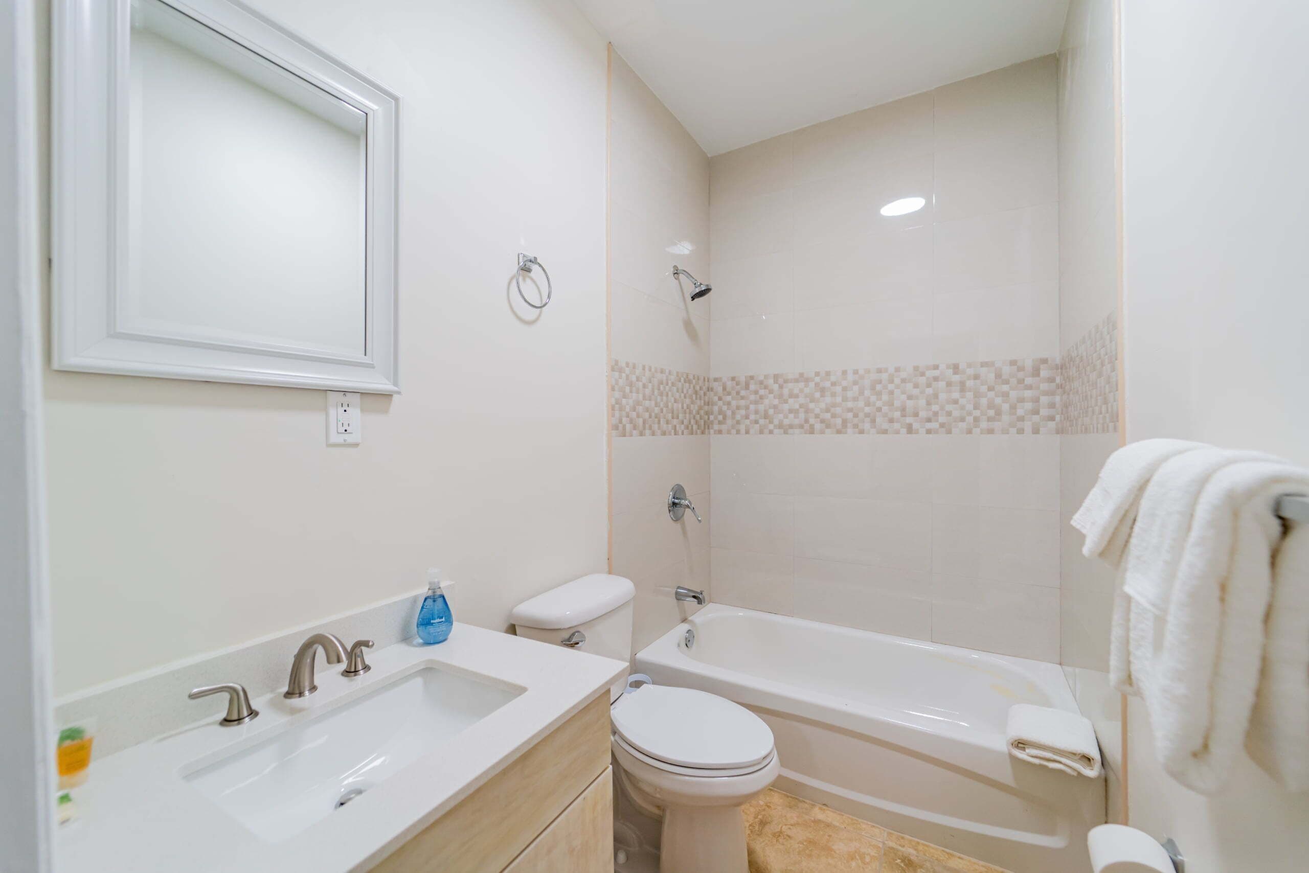 Een badkamer met een wastafel, toilet, bad en douche.