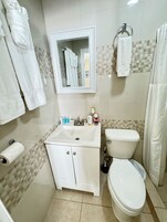 A bathroom with a white sink, toilet, and towel rack.