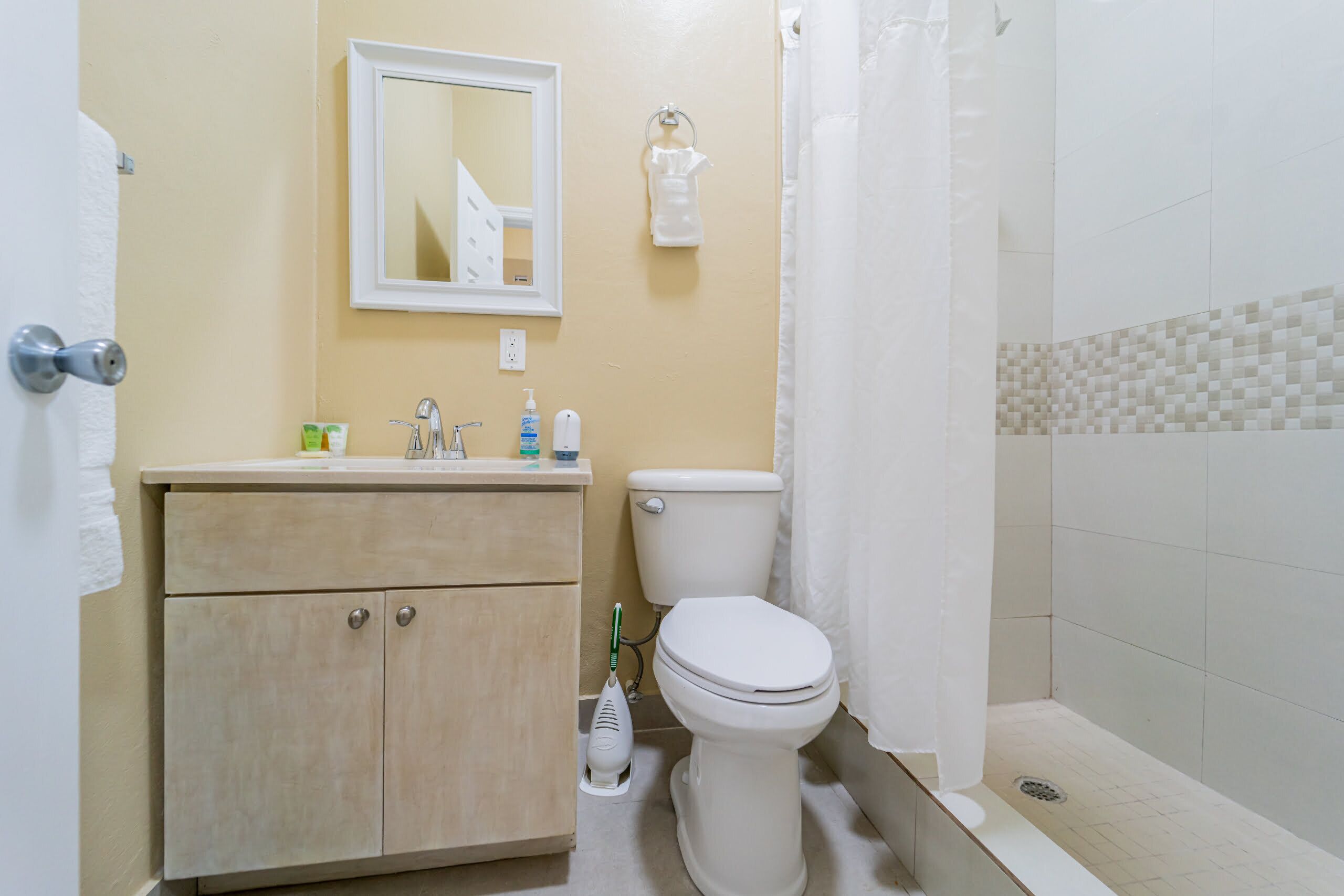 A bathroom with a toilet, sink, and shower.