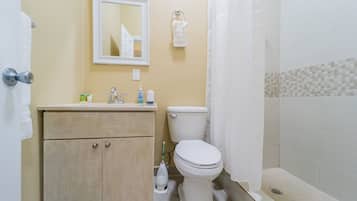 A bathroom with a toilet, sink, and shower.