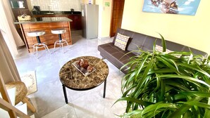 Una sala de estar moderna con un sofá, una mesita de centro y una planta grande.