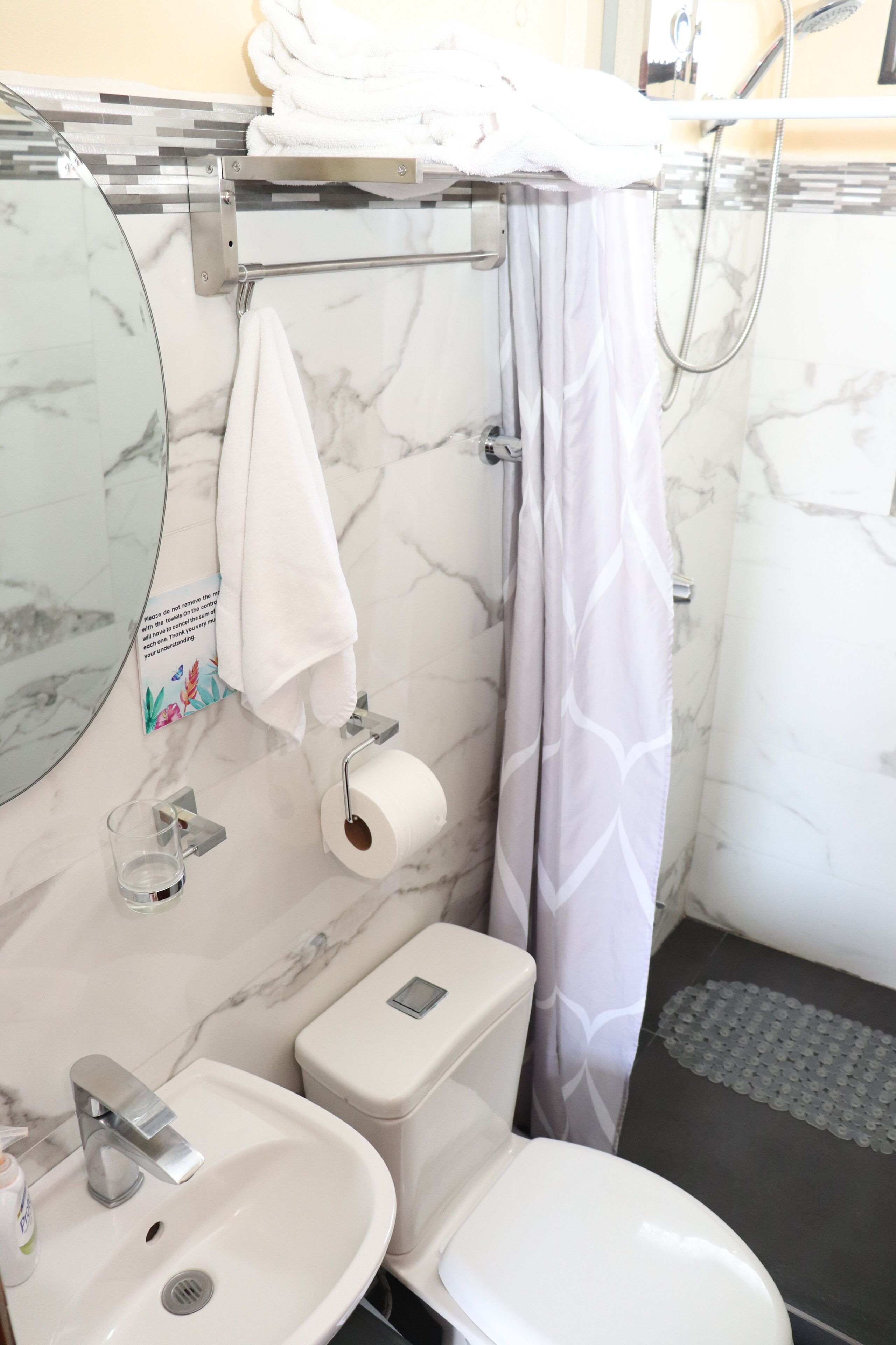 A bathroom with a toilet, sink, and shower.