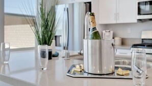 A modern kitchen with a stainless steel pot holding a bottle of champagne, a potted plant, and a tray with glasses and cubes. - Summer specials! Pool+spa+gameroom+putting green (Desert Hot Springs)