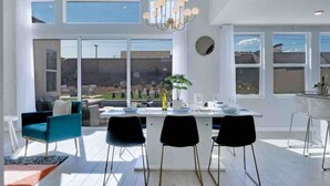 A bright, spacious dining area with a large table, modern chairs, and a chandelier. - Summer specials! Pool+spa+gameroom+putting green (Desert Hot Springs)