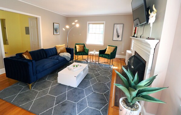 A living room with a blue sofa, green armchairs, a white coffee table, and a large potted plant. - Lofty Elegant Home In Downtown Princeton (Princeton)